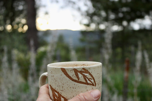 Holding a mug of tea in front of a sunset