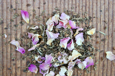 Organic Tulsi Rose loose leaf herbal tea blend with pink rose petals and green leaves