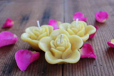 image of three floating rose candles made of yellow beeswax with a cotton wick