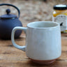 Close-up of speckled oatmeal glaze and unglazed terracotta base on tea cup