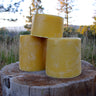 Hand-processed yellow beeswax bricks on rustic wood