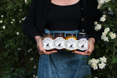 holding naturally infused raw honey infused honey flavored honey chai spice honey smoked hot pepper honey turmeric ginger infused honey butterfly pea flower infused honey