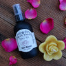 rose water and floating rose candle on wooden surface with rose petals